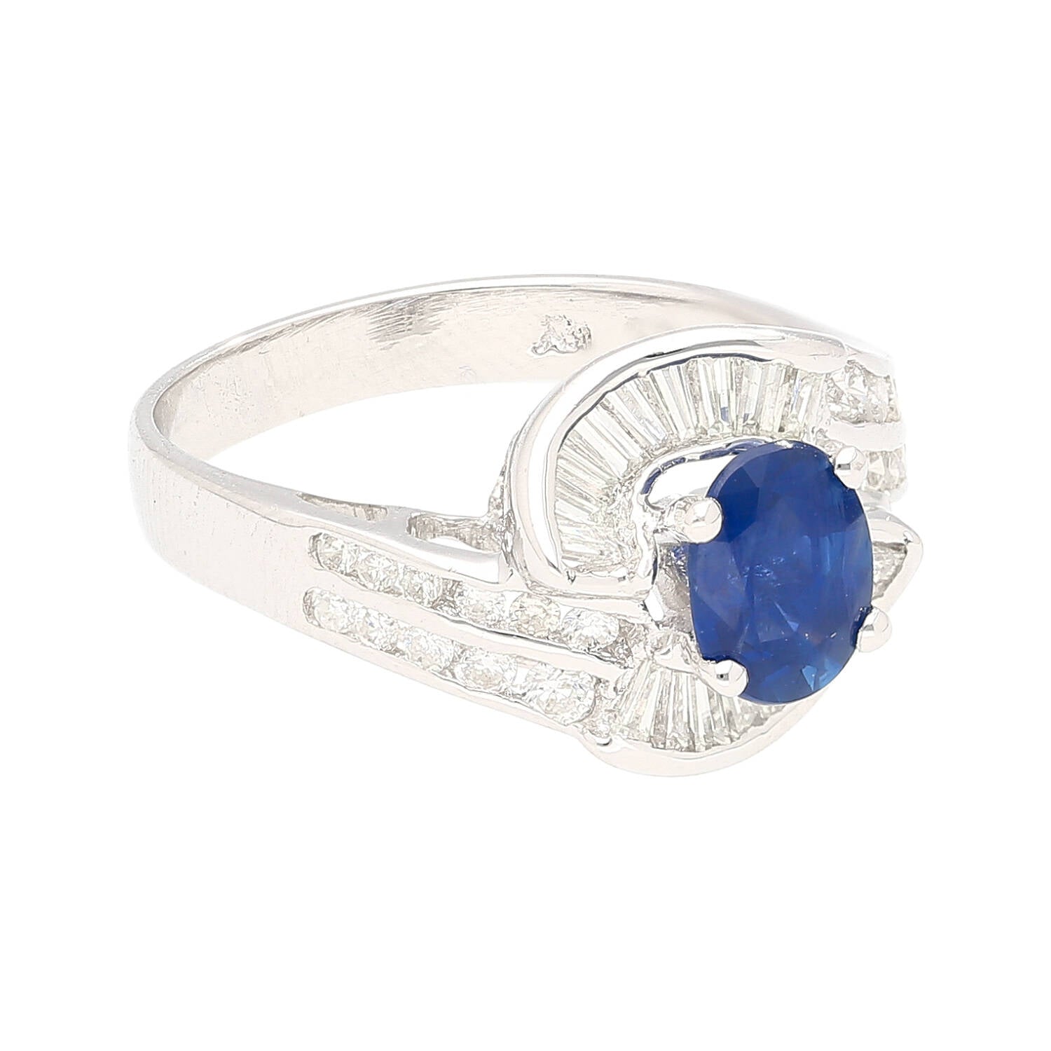 Natural 1.14 Carat Oval Cut Blue Sapphire with Round & Baguette Cut Diamonds in a Swirled 18K White Gold Ring Setting